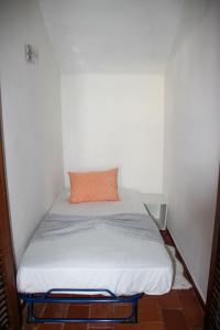 a small room with a bed with an orange pillow at Marina 2 in Vilamoura