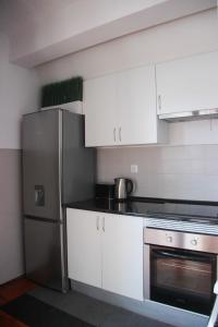 a kitchen with white cabinets and a stainless steel refrigerator at Marina 2 in Vilamoura