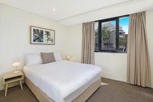 a hotel room with a bed, chair and a window at Breeze Mooloolaba, Ascend Hotel Collection in Mooloolaba