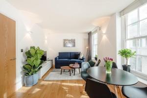 a living room with a blue couch and a table at Fantastic 1 Bedroom Flat Leicester Square West End in London