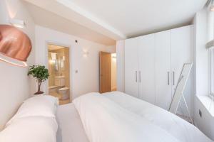 sypialnia z 2 białymi łóżkami i łazienką w obiekcie Fantastic 1 Bedroom Flat Leicester Square West End w Londynie