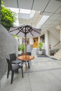 a patio with a table and chairs and an umbrella at Hotel Palace Galapagos in Puerto Ayora