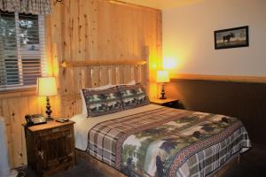1 dormitorio con 1 cama con pared de madera en Fireside Lodge en Big Bear Lake