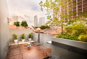 a balcony with chairs and tables on a building at Hotel NuVe in Singapore