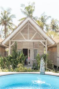 a house with a swimming pool in front of a house at Coconut Village Guest House Lembongan RedPartner in Nusa Lembongan