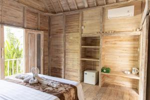 um quarto com uma cama e uma parede de madeira em Coconut Village Guest House Lembongan RedPartner em Nusa Lembongan