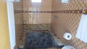 a bathroom with a shower with a stone floor at Casa vivencial Yuraq Qaqa in Coporaque