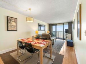 a dining room and living room with a table and chairs at Casa Pelicano - OCEANFRONT LUXURY! Enjoy epic ocean views from this 7th floor dream condo condo in Carolina Beach