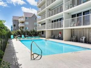 a swimming pool in front of a apartment building at Casa Pelicano - OCEANFRONT LUXURY! Enjoy epic ocean views from this 7th floor dream condo condo in Carolina Beach