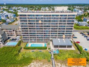 an aerial view of a large building with a pool at Casa Pelicano - OCEANFRONT LUXURY! Enjoy epic ocean views from this 7th floor dream condo condo in Carolina Beach