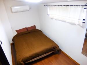 1 dormitorio pequeño con 1 cama en una habitación en Guesthouse Bell Fushimi, en Kioto
