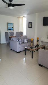 sala de estar con sofá y mesa en Fully Equipped New 2br Apt–dt–2mins To The Beach, en Sosúa