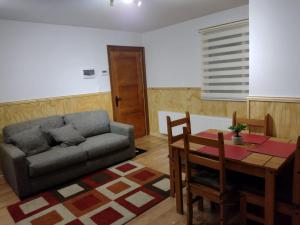 ein Wohnzimmer mit einem Sofa und einem Tisch in der Unterkunft Departamentos Kitkaika in Punta Arenas
