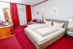 Cama blanca grande en habitación con alfombra roja en Gästehaus Engelgasse Herzogenaurach, en Herzogenaurach