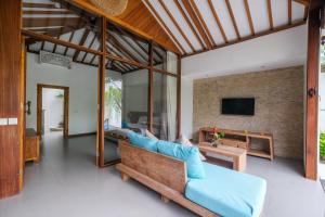 un soggiorno con un divano e una TV di Molokai Suites a Uluwatu