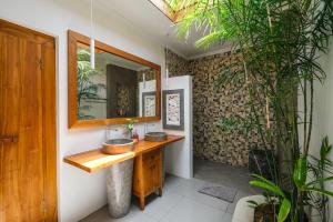 un bagno con lavandino e specchio di Molokai Suites a Uluwatu