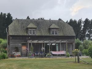 an old house with a hammock in front of it at DDOG Vineyard & BnB in Renwick