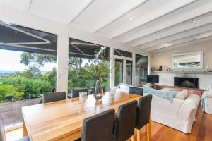 a dining room with a table and a couch at The Grove in Lorne