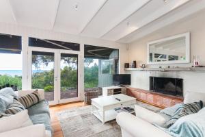 a living room with two couches and a fireplace at The Grove in Lorne