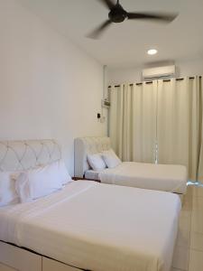 two beds sitting next to each other in a room at Reco Villa Private Pool 4 Bedrooms@ Taman Mayung Teluk Kemang Port Dickson in Port Dickson