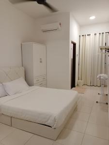 a white bedroom with a large white bed in a room at Reco Villa Private Pool 4 Bedrooms@ Taman Mayung Teluk Kemang Port Dickson in Port Dickson