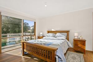 a bedroom with a bed and a large window at Apollo Bay People N Paws in Apollo Bay