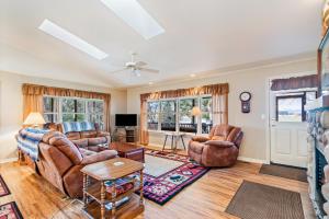 a living room with two couches and a tv at The Wild Rose in Sagle