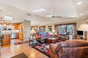 a living room with leather furniture and a kitchen at The Wild Rose in Sagle