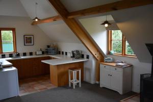an attic kitchen with a counter top and some windows at DDOG Vineyard & BnB in Renwick