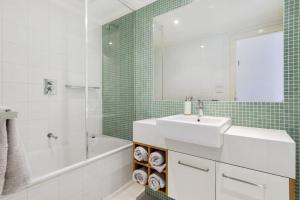 Un baño con lavabo, bañera y espejo. en Apollo Blue 11, en Apollo Bay 4 fotos más