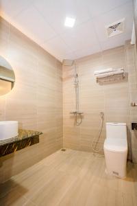 a bathroom with a toilet and a sink at Khách Sạn Đại Dương FLC Sầm Sơn in Sầm Sơn