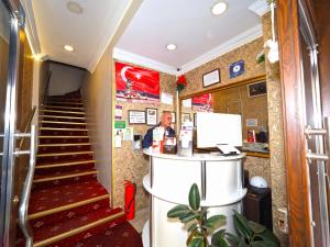 a lobby with a staircase and a man at a counter at Seyri Istanbul Hotel in Istanbul