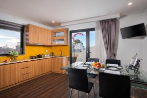 a kitchen and dining room with a table and chairs at Hanoi Paon Hotel & Spa in Hanoi