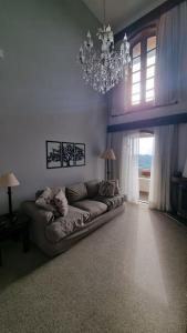 salon z kanapą i żyrandolem w obiekcie Flat duplex Quatre Saisons com linda vista panorâmica w mieście Campos do Jordão