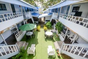 an outdoor patio with tables and chairs and an umbrella at Boracay Morning Beach Resort in Boracay