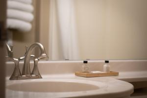 La salle de bains est pourvue d'un lavabo, d'un sèche-cheveux et de serviettes. dans l'établissement Monument Inn & Suites, à Gering