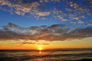 un tramonto sull'oceano con un cielo nuvoloso di 旅行者之家精緻漫旅-近火車站 a Città di Hualien