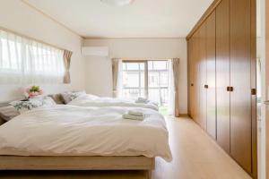 Un dormitorio con una gran cama blanca y una ventana en Terrace Kyobate （Vacation house in Nara） en Nara