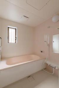 a white bathroom with a bath tub and a window at Terrace Kyobate （Vacation house in Nara） in Nara