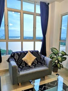 un sofá en una sala de estar con una gran ventana en Embun Sky Cottage - Kota Bharu, WIFI, 6 - 8 Pax, en Kota Bharu