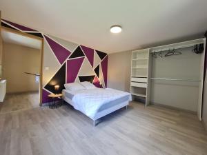 um quarto com uma cama com uma parede colorida em Le Gîte du Petit Béret em Plainfaing