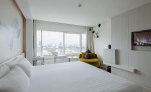 Centara Watergate Pavilion Hotel Bangkok في بانكوك: غرفة فندقية بسرير كبير ونافذة