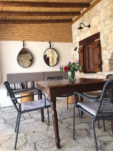 comedor con mesa de madera y sillas en House of Eleni, en Káthikas