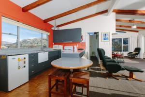 a kitchen with orange walls and a table and chairs at Panorama Court in Wanaka