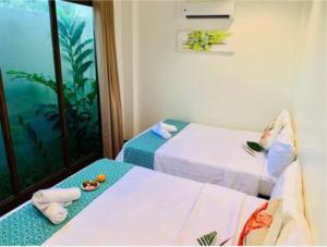 pokój hotelowy z 2 łóżkami i oknem w obiekcie The Orient Beach Boracay w mieście Boracay