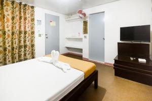 a hotel room with a bed and a flat screen tv at Boracay Morning Beach Resort in Boracay