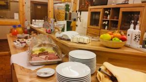 - une cuisine avec un comptoir avec des assiettes et des fruits dans l'établissement Landhotel Solmser Hof, à Echzell