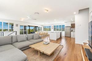 a living room with a couch and a table at Cowrie House - Spacious, Modern holiday home in Yamba