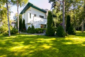 a white house with a yard with trees and a house at Villa in Tallinn near beach in Tallinn