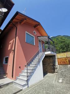 ein rotes Haus mit einer Treppe nebeneinander in der Unterkunft GM HOUSE in Gravedona
